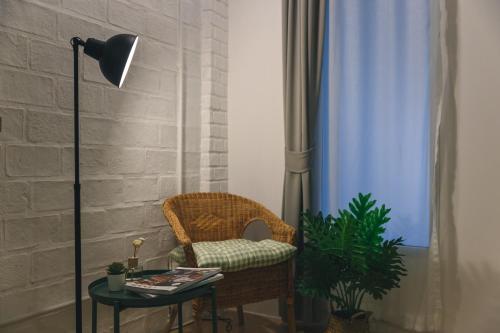 a room with a chair and a table with a lamp at Yindee Travellers Lodge in Nan