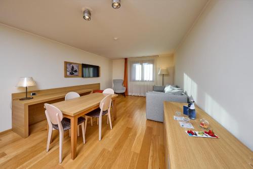 a living room with a table and chairs and a couch at Blu Hotel Acquaseria in Ponte di Legno