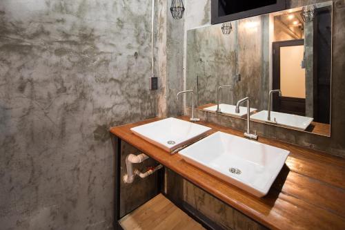 a bathroom with two sinks and a mirror at Yindee Travellers Lodge in Nan