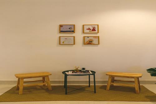 two benches and a table with two tables and two chairs at Yindee Travellers Lodge in Nan