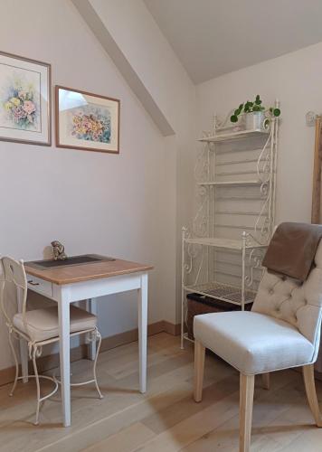 a dining room with a table and a chair at Le Repos Coquelicot in Montillot
