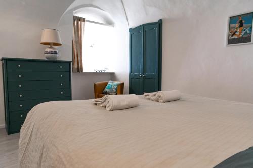 a bedroom with a bed with two towels on it at Il Carrugio in Ospedaletti