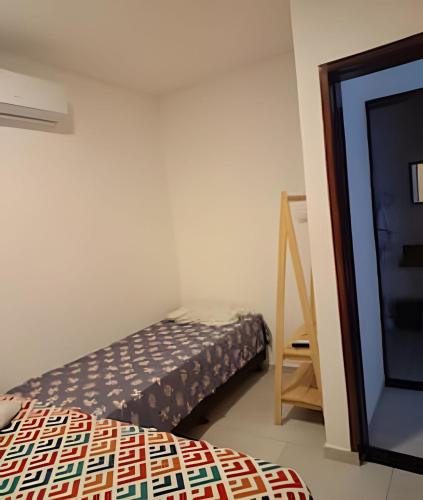 a small bedroom with a bed and a mirror at Refuge Aldeia dos Camarás in Camaragibe