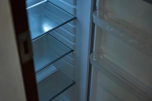 an empty refrigerator with glass shelves in it at Loukaz -entire Rental Units W Panoramic Rooftop in La Gaulette