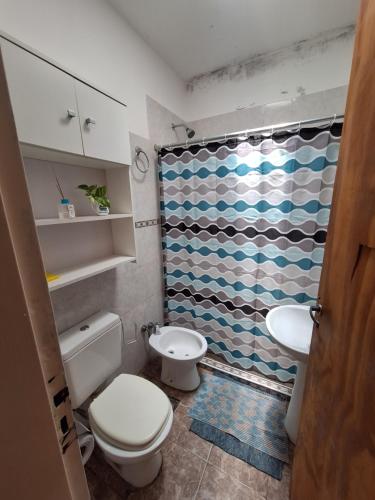 ein Badezimmer mit Toilette und Duschvorhang in der Unterkunft Dpto Lu 2 in Villa Mercedes
