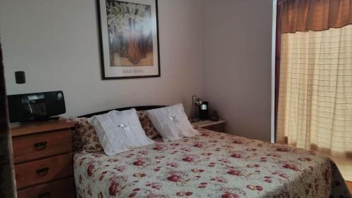 sypialnia z łóżkiem z narzutą i telewizorem w obiekcie KositasRikas B&B w mieście Viña del Mar