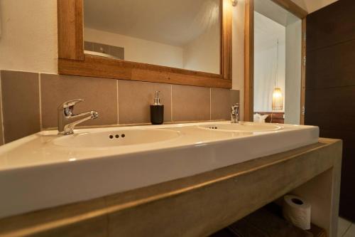a bathroom with two sinks and a mirror at Loukaz -entire Rental Units W Panoramic Rooftop in La Gaulette