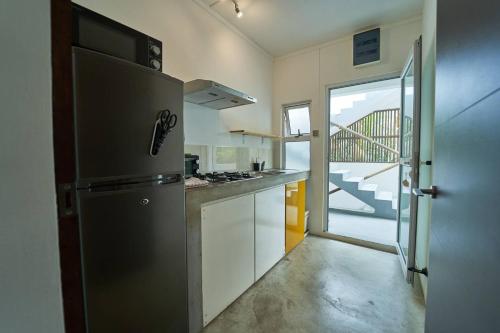 a kitchen with a refrigerator and a door to a balcony at Loukaz -entire Rental Units W Panoramic Rooftop in La Gaulette