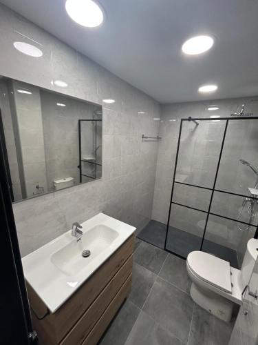 a bathroom with a sink and a shower and a toilet at Apartamento Europa con terraza in Blanes