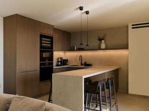 a kitchen with a counter and some chairs in it at Mykonos Rocks Villas & Suites in Mýkonos City