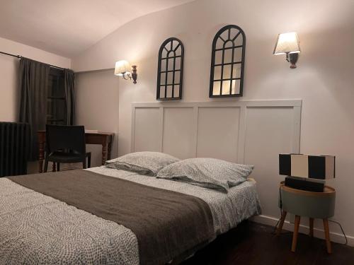 een slaapkamer met een bed en twee ramen aan de muur bij 4 - Les pins roses in Poitiers