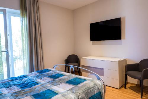 a bedroom with a bed and a flat screen tv at La Villetta Nicolini in Barbaresco