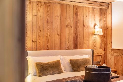 a bedroom with a bed with a wooden wall at Haus Gabriel - Seefeld in Seefeld in Tirol