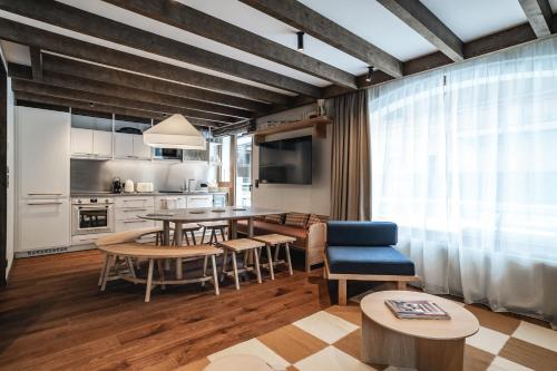 a kitchen and living room with a table and chairs at Appartements de l'Héliopic in Chamonix-Mont-Blanc