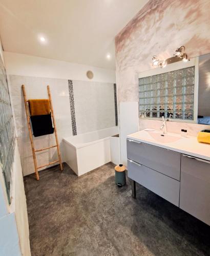 une salle de bain avec une baignoire et un lavabo et une baignoire dans l'établissement Les Orangers - LOGEMENT INDÉPENDANT - 2 personnes - Patio - PROCHE DES THERMES DE SAUJON, DU GOLF ET DU CENTRE DE ROYAN, à Royan