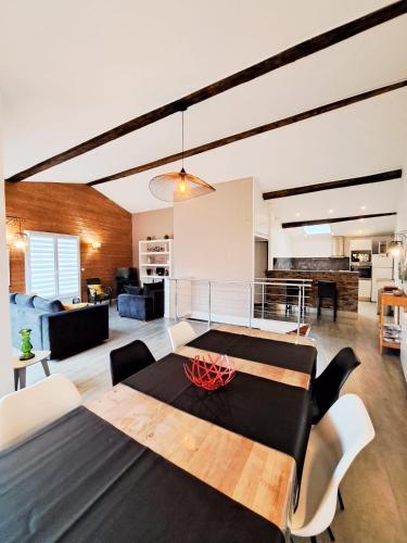 - une salle à manger et un salon avec une table dans l'établissement Les Orangers - LOGEMENT INDÉPENDANT - 2 personnes - Patio - PROCHE DES THERMES DE SAUJON, DU GOLF ET DU CENTRE DE ROYAN, à Royan