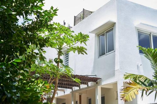a white house with trees in front of it at Loukaz -entire Rental Units W Panoramic Rooftop in La Gaulette