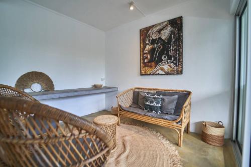 a living room with a wicker chair and a rug at Loukaz -entire Rental Units W Panoramic Rooftop in La Gaulette