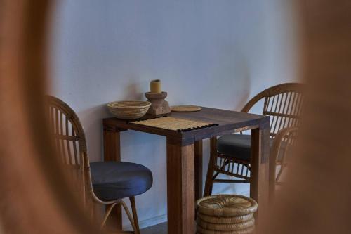 a wooden table with four chairs and a table with a table at Loukaz -entire Rental Units W Panoramic Rooftop in La Gaulette