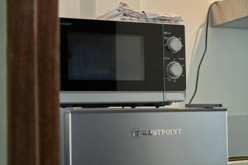 a microwave sitting on top of a refrigerator at Loukaz -entire Rental Units W Panoramic Rooftop in La Gaulette