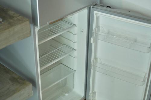 an empty refrigerator with its door open in a kitchen at Loukaz -entire Rental Units W Panoramic Rooftop in La Gaulette
