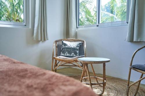 a chair and a stool in a room with windows at Loukaz -entire Rental Units W Panoramic Rooftop in La Gaulette