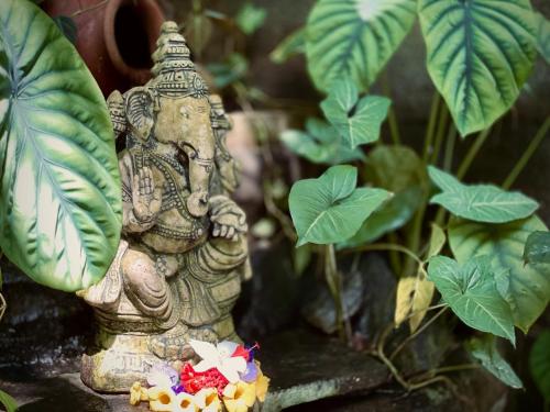 a statue of an elephant standing in front of plants at Bananas Mirissa in Mirissa
