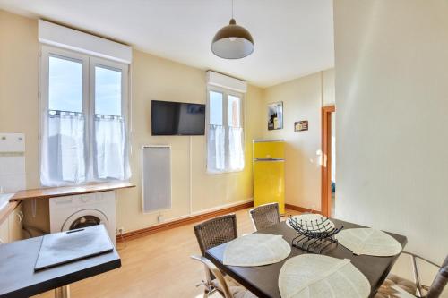 une salle à manger avec une table et des chaises et une télévision dans l'établissement Appartement khristina, à Toulouse