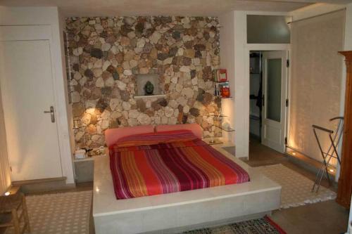 1 dormitorio con 1 cama con pared de piedra en Complejo La Ermita en Rodalquilar