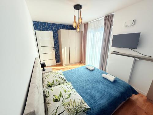 ein Schlafzimmer mit einem Bett und einer blauen Decke in der Unterkunft Vistula Avenue Apartment free Parking, Swimming Pool, Sauna & Gym in Krakau