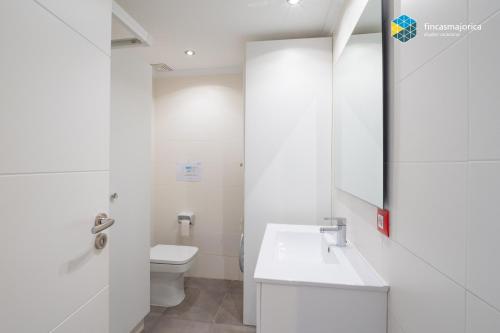 un bagno bianco con un water e un lavandino di Apto Antic 302 Pax 4 a S'Illot