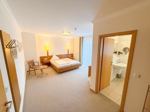 a hotel room with a bed and a bathroom at Hotel Up de Birke in Ladbergen