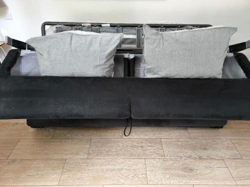 - un lit noir avec 2 oreillers dans l'établissement COSY 2P A 5 MINUTES A PIED DE LA MER ET DU CENTRE, à Menton