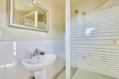 une salle de bain blanche avec un lavabo et un miroir dans l'établissement Appartement khristina, à Toulouse