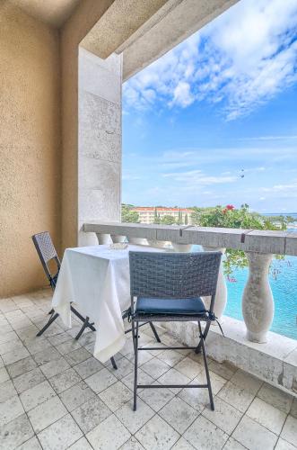 a table and chairs on a balcony with a view of the ocean at Brijuni Hotel Neptun in Fažana