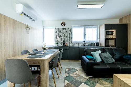 a living room and kitchen with a table and a couch at Mátravölgy Apartmanház in Pásztó