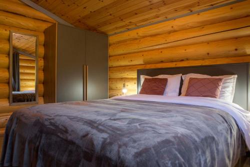 a bedroom with a large bed in a log cabin at Vucje Brdo in Kolasin in Kolašin