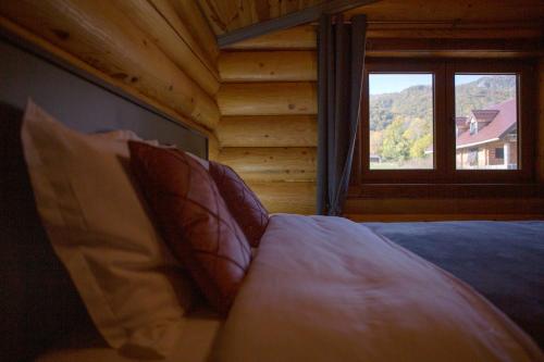 a bedroom with a bed and a window in a log cabin at Vucje Brdo in Kolasin in Kolašin