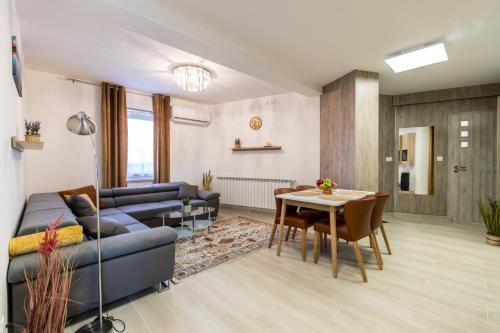 a living room with a blue couch and a table at Mátravölgy Apartmanház in Pásztó