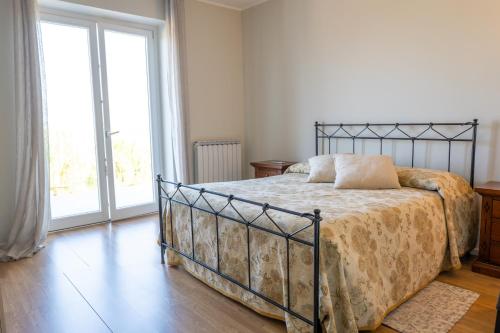 a bedroom with a bed and a large window at La Villetta Nicolini in Barbaresco