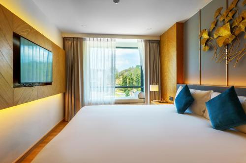 ein Schlafzimmer mit einem großen weißen Bett mit einem Fenster in der Unterkunft Super 2Bdr Apartament La Vita Rawai Naiharn beach in Rawai Beach