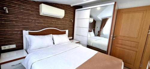 a bedroom with a large white bed and a mirror at Taksim Flat in Istanbul