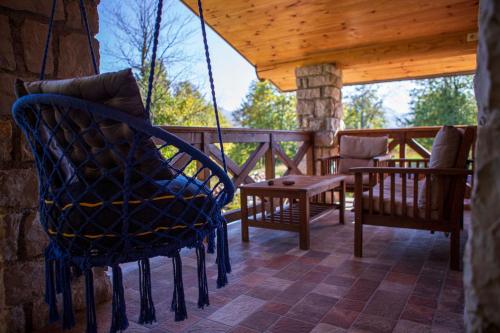 a porch with chairs and a swing on a deck at Vucje Brdo in Kolasin in Kolašin