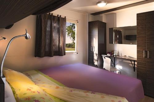 a bedroom with a large bed and a desk at hu I Pini village in Fiano Romano