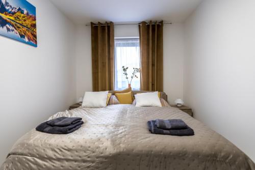 a bedroom with a bed with two towels on it at Mátravölgy Apartmanház in Pásztó