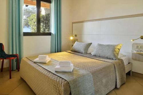 una camera da letto con un letto con due asciugamani sopra di Charmante maison à Olmeto avec piscine partagée a Olmeto