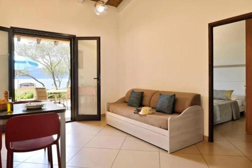 un salon avec un canapé et une table dans l'établissement Charmante maison à Olmeto avec piscine partagée, à Olmeto