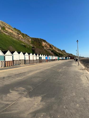an empty street with a row of beach huts at Coastal Charm and Tranquility in our Studio Guest House in Bournemouth