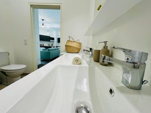 a white bathroom with a sink and a toilet at Horizon House - Roissy CDG - Parc des Expos in Villepinte
