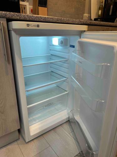 an empty refrigerator with its door open in a kitchen at Coastal Charm and Tranquility in our Studio Guest House in Bournemouth